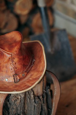 Kovboy başlığı. Deri şapka ağaç kütüğünün üzerinde.