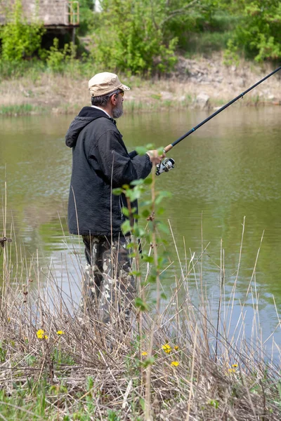 Hombre Una Chaqueta Pesca Con Una Caña Hilar Orilla Embalse —  Fotos de Stock