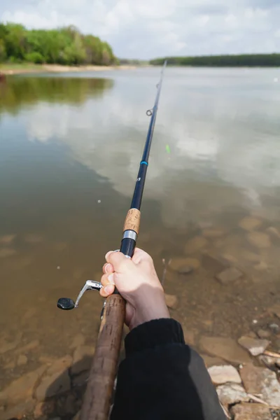 Fiskare Håller Ett Spinnspö Med Rulle Ovanför Ytan Dammen Vatten — Stockfoto