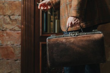 Şık bir ceketi olan beyefendinin elinde bir vintage ve bir ba...