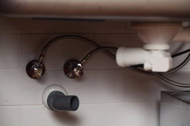 Metal mutfak lavabosunun altında parçalanmış Weir sistemi yakın plan. Yan çizgi