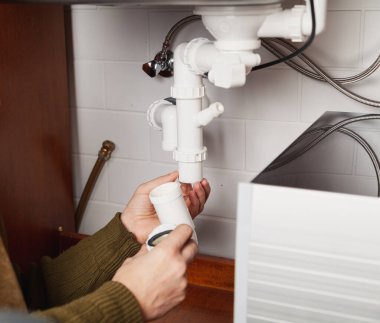 Hijyenik teknisyenin elleri mutfak hidrolik deklanşör sistemini kapatır.