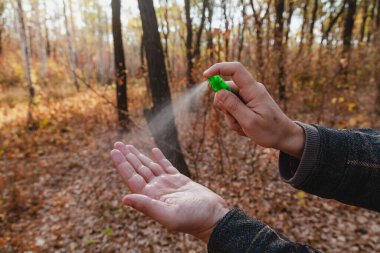 Enfeksiyonu önlemek için. Bir adamın elleri bir şişe sprey antiseptiğin kapağına basar. Kapat.