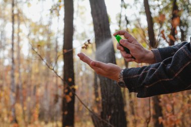 Enfeksiyonu önlemek için. Bir adamın elleri bir şişe sprey antiseptiğin kapağına basar. Kapat.