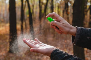 Enfeksiyonu önlemek için. Bir adamın elleri bir şişe sprey antiseptiğin kapağına basar. Kapat.