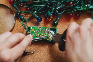 Yeni yıla hazırlanıyorduk. Köknar ağacı elektrik çelengi tamiri. Bir elektrikçinin, makasın ve cımbızın ellerinde