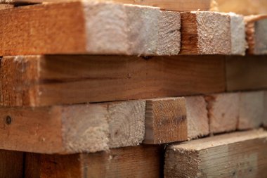 Kare şeklinde tahta bloklar farklı yönlerde birkaç katman halinde sıkıca katlanmış. Kapat.