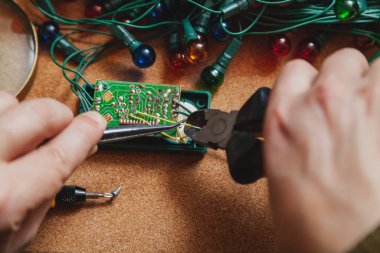 Yeni yıla hazırlanıyorduk. Köknar ağacı elektrik çelengi tamiri. Bir elektrikçinin, makasın ve cımbızın ellerinde