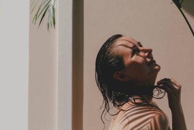 Doğal kusurlarıyla rötuş yapmadan çıplak omuzlu güzel bir kızın portresi. Yukarıda Howe palmiyesinin yeşil bir dalı yetişiyor. Palmiye ağacı berrak bir gölge verir