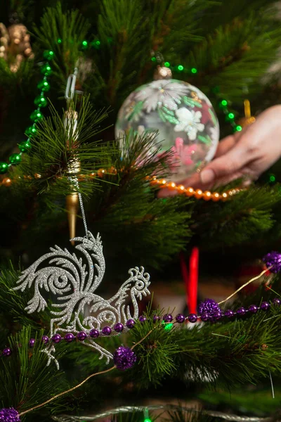 一只公鸡银质雕像的特写在一棵新年树上的树枝上 原来的圣诞树到 — 图库照片
