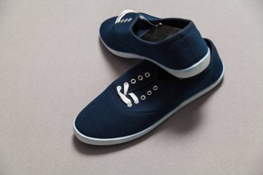 Beyaz tabanlı ve bağcıklı iki yeni mavi spor ayakkabı beyaz, izole bir arka planda duruyor.