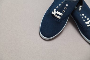 Beyaz tabanlı ve bağcıklı iki yeni mavi spor ayakkabı beyaz, izole bir arka planda duruyor.