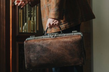 Şık bir ceketi olan beyefendinin elinde bir vintage ve bir ba...