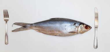 Omul 'la hayat devam ediyor. Güzel balık yumurtası beyaz kağıda yakın planda yatar. Solda bir çatal var. Sağ düğüm