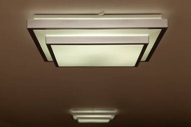 Düz kare aydınlatma, beyaz tavanda kremalı ışık.