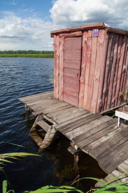 Ahşap platform göl suyunun yüzeyine kurulur. Orada uzun tahta bir kabin var.