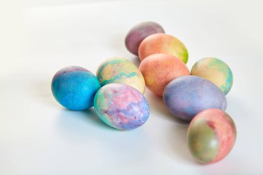 Paskalya tatiline özen göster. Farklı renklerde boyanmış birkaç tavuk yumurtası beyaz bir sırt grubunda.