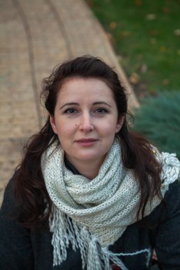 Güz parkının ortasında uzun kızıl saçlı güzel bir kadın duruyor. Bir ağacın sarı yaprağını tutuyor. Doğal kusurlarıyla rötuşsuz bir kadın portresi.