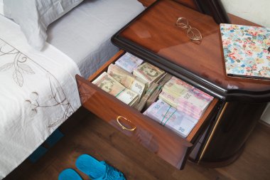 Bundles of banknotes in bedside table clipart