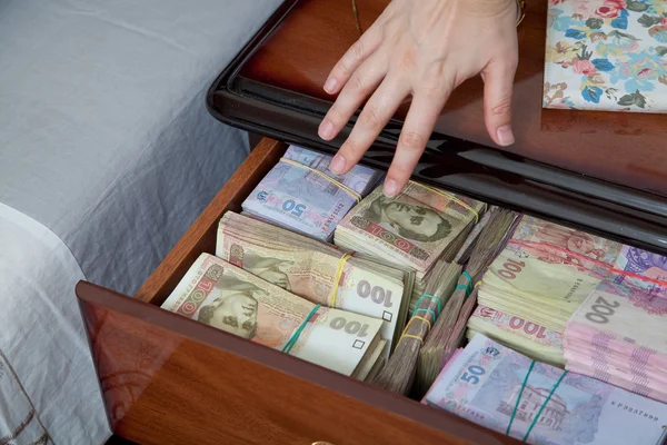 Hand reaches for the money in bedside table — Stock Photo, Image