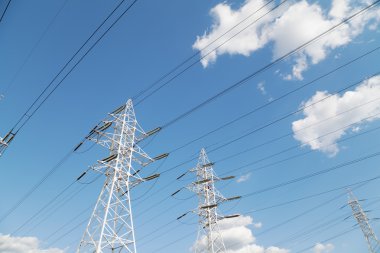Güç iletim hatları mavi gökyüzüne karşı