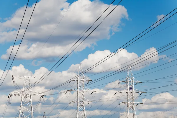 Linhas de transmissão de energia contra o céu azul — Fotografia de Stock