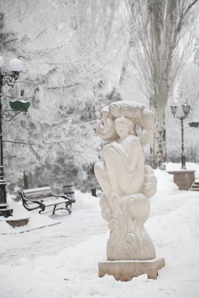 Escultura coberta de neve em uma avenida de inverno da cidade — Fotografia de Stock