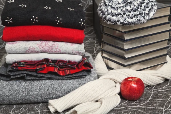 Stack of winter clothes and books with silver edge — Stock Photo, Image