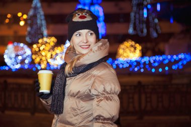 Arka plan üzerinde st ışıkları ile gülümseyen sarışın kız ayakta