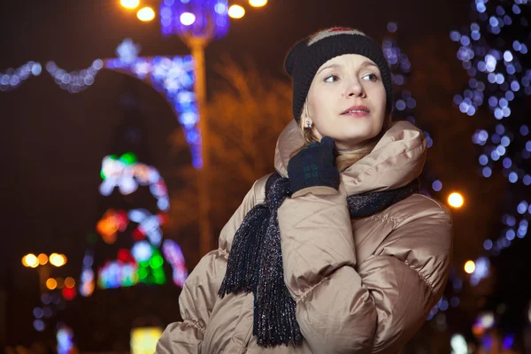 Hermosa chica rubia de pie sobre el fondo con luces en el —  Fotos de Stock