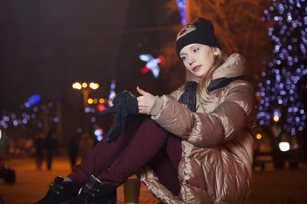 Hermosa chica rubia sentada en el fondo con luces en el s —  Fotos de Stock