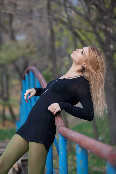 Hermosa mujer rubia apoyada en la barandilla de la pasarela — Foto de Stock