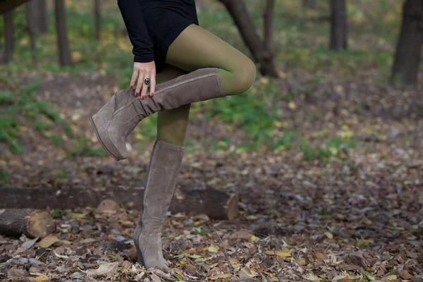 Bella donna gambe in stivali di camoscio nella foresta di autunno — Foto Stock