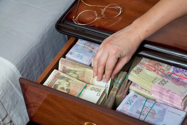 手掏出钞票从床边的桌子 — 图库照片