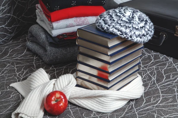 Stack av vinterkläder och böcker med glansiga kant — Stockfoto