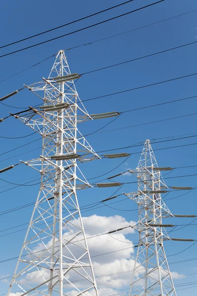 Líneas de transmisión de energía contra el cielo azul —  Fotos de Stock