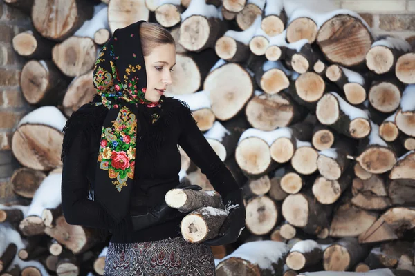 Mulher loira atraente na varanda de inverno no fundo de lenha — Fotografia de Stock