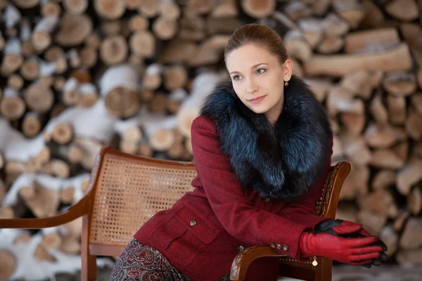 Retrato de invierno de la niña sobre una leña de fondo —  Fotos de Stock