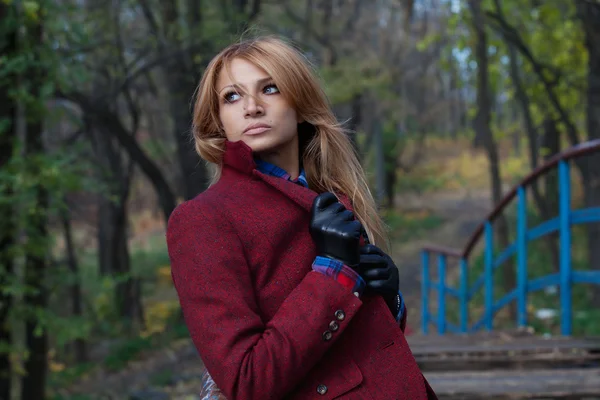 Beautiful thoughtful blonde woman in jacket and leather gloves i — Stock Photo, Image