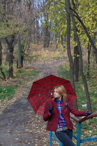 Красивая блондинка с зонтиком в руках позирует на мосту — стоковое фото