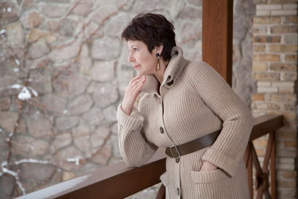 Attractive elderly woman posing on outdoor terrace in winter — Stock Photo, Image