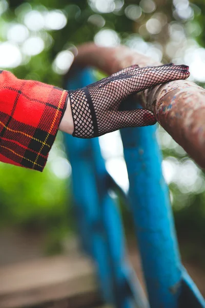 Horsewoman hand in fishnet glove lies on old railing — Stock Photo, Image