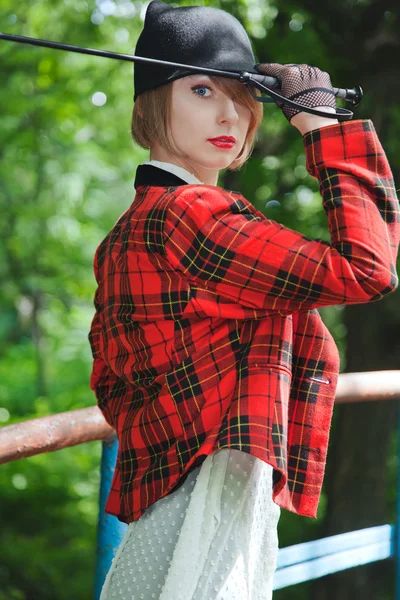 Schöne junge Frau im Reiteranzug spaziert im Wald — Stockfoto