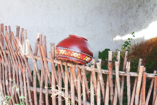 Глиняный горшок на заборе — стоковое фото