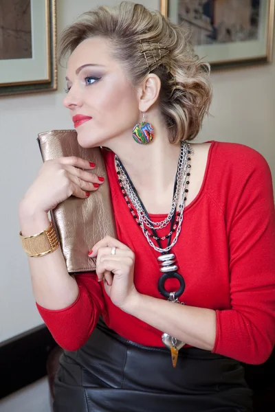 एक लाल स्वेटर में सुंदर सुनहरे बालों वाली महिला प्रोफ़ाइल में पोस्टिंग — स्टॉक फ़ोटो, इमेज