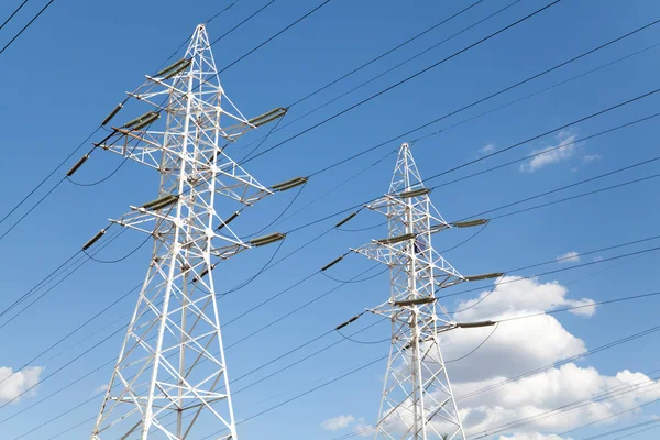 Líneas de transmisión de energía contra el cielo azul —  Fotos de Stock