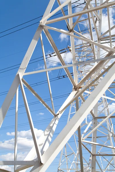 Visão inferior linhas de transmissão de energia contra o céu azul — Fotografia de Stock