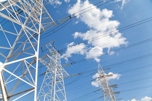 Líneas de transmisión de energía contra el cielo azul —  Fotos de Stock