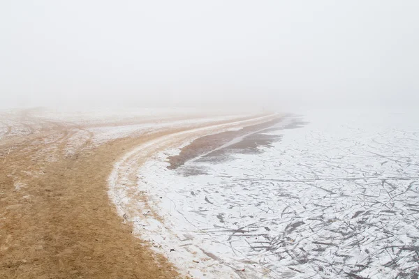 Sandy beach by the river in the fog in winter — Stock Photo, Image