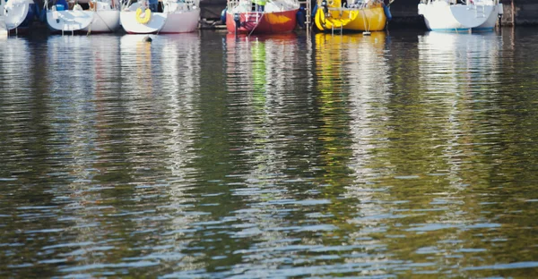 Reflection of boats in green river water — Stock Photo, Image